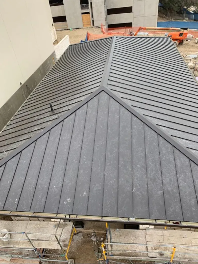 Commercial metal roof construction with crane equipment in North Syracuse